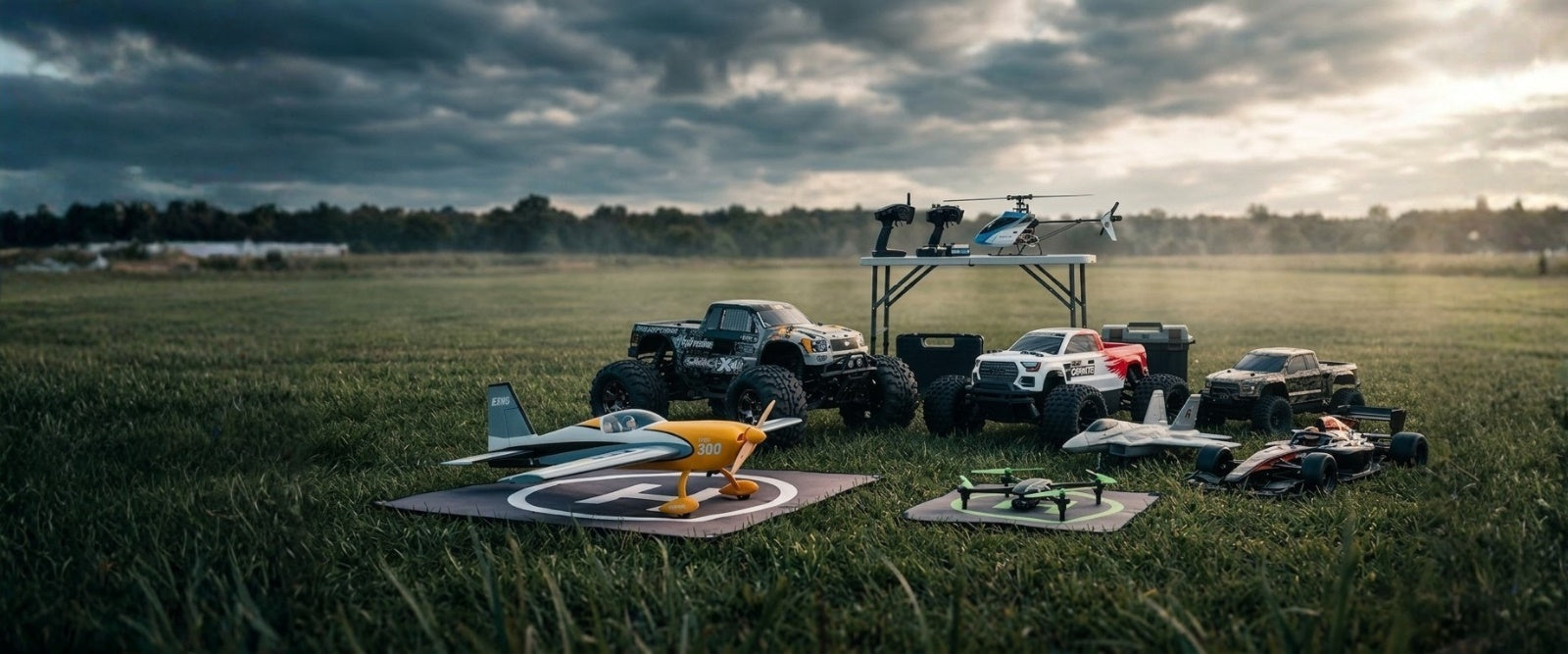 Model airplanes and vehicles on a grassy field with a cloudy sky.